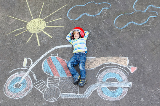 Little child in helmet with motorcycle picture drawing with colo