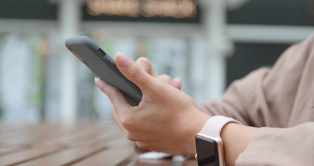 Woman using mobile phone at outdoor restaurant