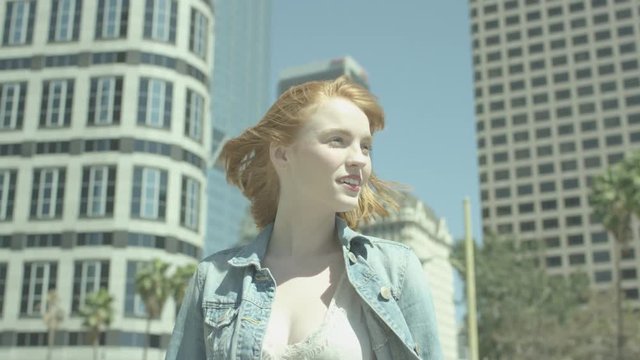 Portrait of young woman with red hair in sunlight slow motion