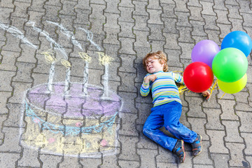 Kid boy having fun with colorful birthday cake drawing with chal