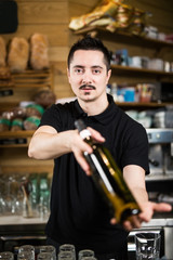 Male barista serving a bottle of wine