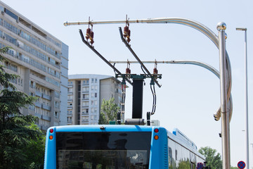 Electric bus at a stop is charged by pantograph