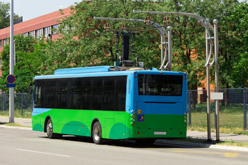 Naklejka na ściany i meble Electric bus at a stop is charged by pantograph