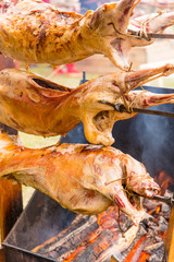 Lamb carcasses roasting on skewers - closeup