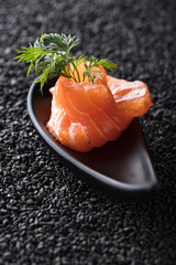 Salted salmon with dill on the background of black sesame.