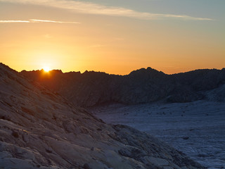 Sun rising behind the profile of the mountains, Adamello glacier, Trentino, Italy