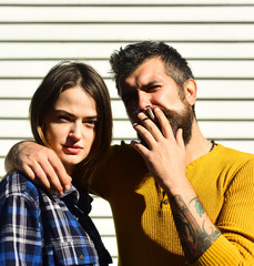 Man and woman with arrogant faces on white striped background.