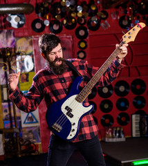 Obraz premium Musician, frontman, soloist, singer play guitar in music club on background. Rock musician concept. Man on shouting face play guitar, singing song, play music. Musician with beard play electric guitar