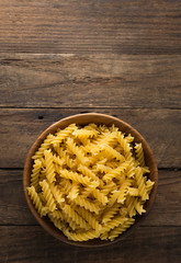 raw pasta in wood plate on wood background