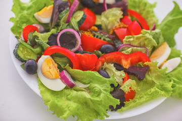 salad from fresh vegetables in a plate on a table, selective focus