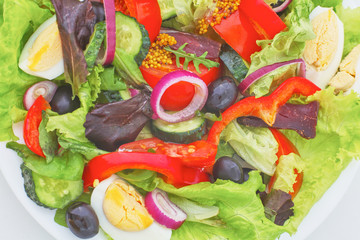 salad from fresh vegetables in a plate on a table, selective focus