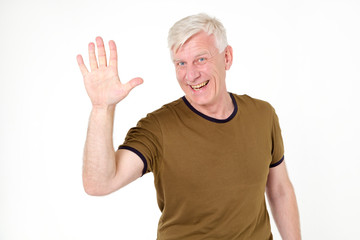 Hello! An adult man with gray hair makes a welcome gesture with his hand. The finger gesture is five.
