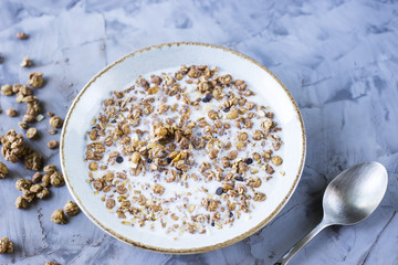 Chocolate muesli with milk in a plate on a gray table. Delicious healthy breakfast