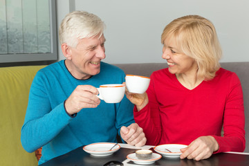 An adult couple. A man and a woman, middle-aged, drink coffee together.