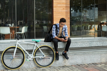 Asian Cyclist Taking Break