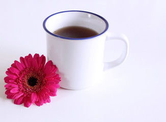 Gerbera flower and a hot cup of tea on wooden table. Seasonal, morning tea, Sunday relax and still life concept. Free place for text.Food concept.