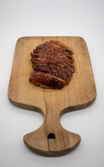 Roasted duck on wooden cutting board isolated on white