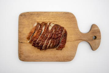 Roasted duck on wooden cutting board isolated on white