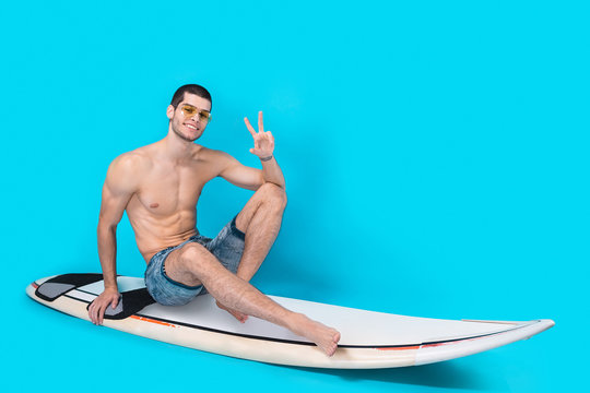 Cheerful surfer showing victory sign
