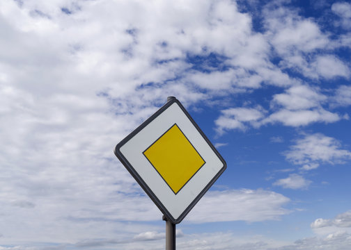 Traffic Signs / Germany: Priority road sign in front of a cloudy blue sky