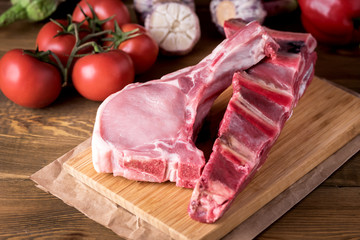 Raw Meat Slices on a Wooden Rustic Background with Fresh Organic Vegetables Garlic,Tomatoes Pepper for Cooking Kitchen ideas Lunch Dinner