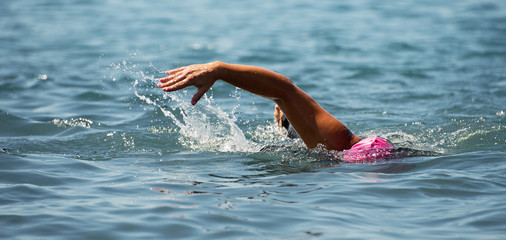 Man swimmer swimming crawl in blue sea,training for triathlon