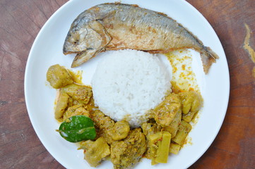batter fried mackerel coating egg yolk and boiled chicken bamboo shoot curry with rice on plate