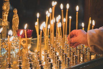 Many candles glowing on table in orthodox church. - obrazy, fototapety, plakaty