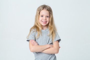 Portrait of a beautiful happy little girl on a light background. Smiling face.