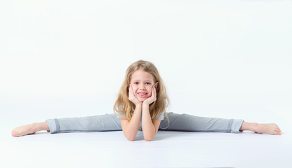 Fototapeta na wymiar Little girl is sitting on a gymnastic twine.