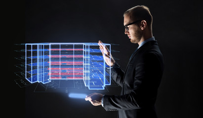 architecture, technology and construction concept - businessman with transparent tablet pc computer and virtual building blueprint projection