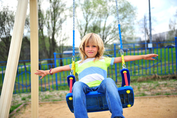 Cute blond boy on the swing