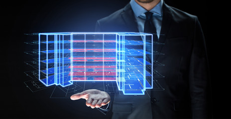 architecture, technology and construction concept - close up of businessman with virtual building blueprint projection