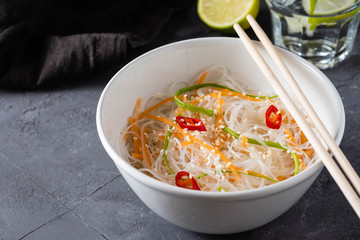 Bean thread noodles salad with cucumber and carrot on a plate close-up.