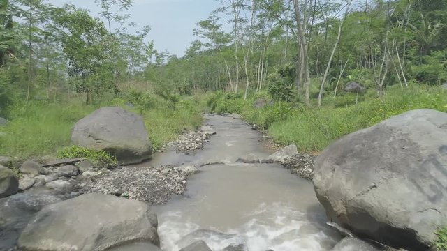 Boulder volcanic rocks in small river aerial footage, Ledok Sambi village, Yogyakarta, Indonesia. April 2018