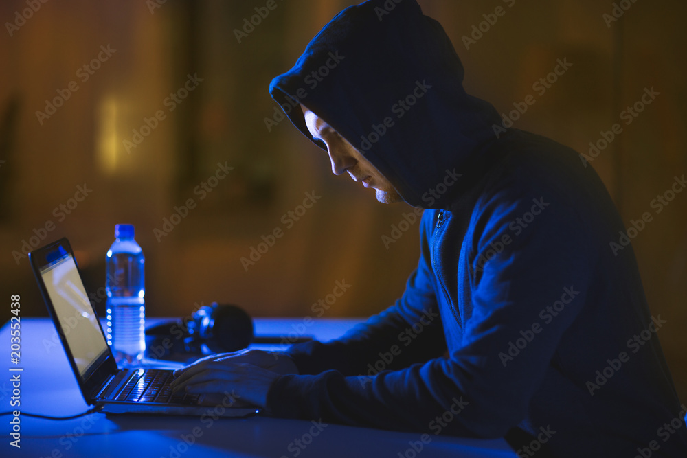 Aufkleber cybercrime, hacking and technology crime - male hacker in dark room using laptop computer for cyber 