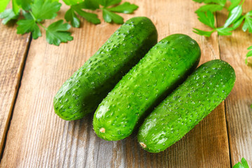Fresh green homemade cucumber with parsley on an old wooden table.