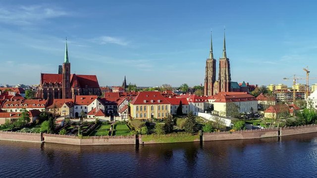 Poland. Wroclaw. Ostrow Tumski, Gothic cathedral of St. John the Baptist,  Collegiate Church of the Holy Cross and St. Bartholomew, park, and Odra (Oder) River. Aerial 4K footage at sunset.

