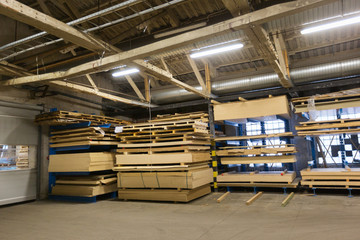 production, manufacture and woodworking industry concept - boards storing at factory warehouse