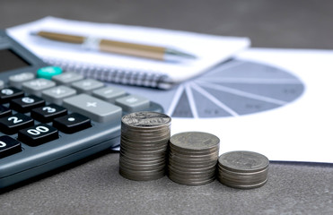 coins, calculator, pen and graph on table accounting business or financial concept.