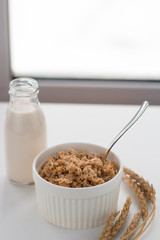 oatmeal and milk on the table near  the window