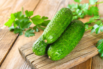 Fresh green homemade cucumber with parsley on an old wooden table.