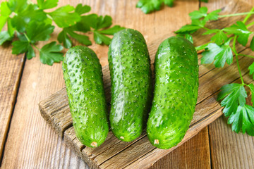 Fresh green homemade cucumber with parsley on an old wooden table.