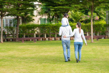 Cute Asian girl on neck parents big happy laughing and run around together.Happy family piggybacking adorable little daughter is smiling.