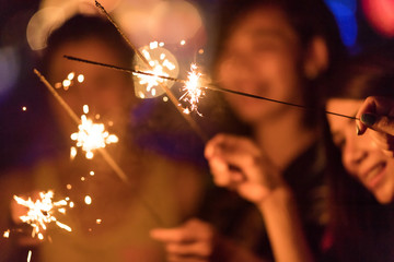 Blurred of Sparklers with group of friends having fun for celebration and hand holding a burn...