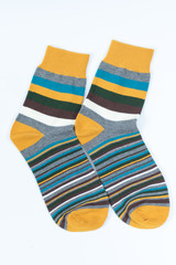 A pair of striped socks. Stripes color: mostard, turqoise, white and gray.