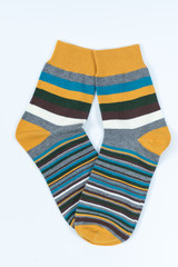 A pair of striped socks. Stripes color: mostard, turqoise, white and gray.