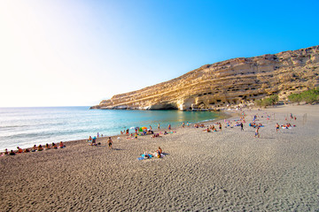 Matala beach with caves on the rocks that were used as a roman cemetery and at the decade of 70's were living hippies from all over the world, Crete, Greece