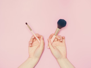 cosmetic and beauty concept from beauty asian hand hold and use cosmetic brush with isolated pink pastel background