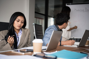 Obraz premium Young business woman is boring. People and crisis concept. Young woman is sitting sad and solving problem in office. Setup studio shooting.